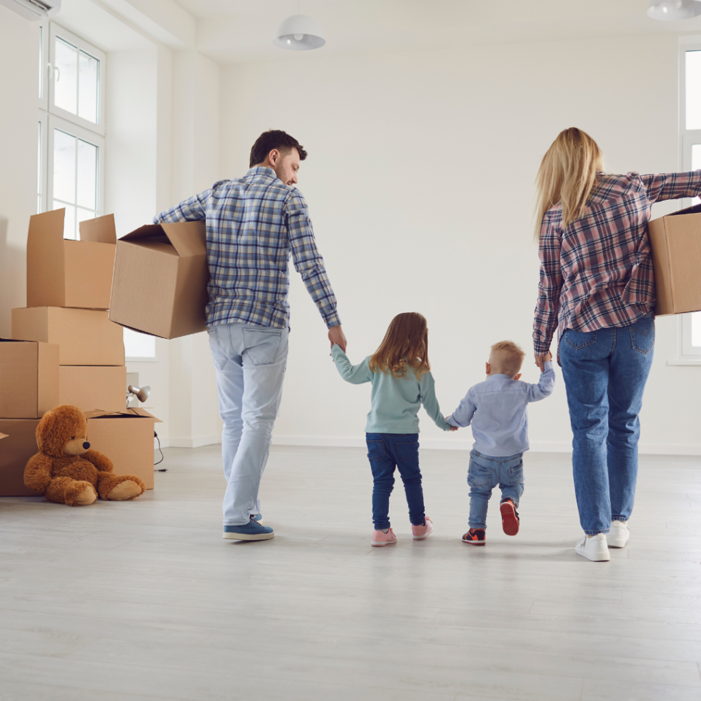 parents holding hands with kids with moving boxes